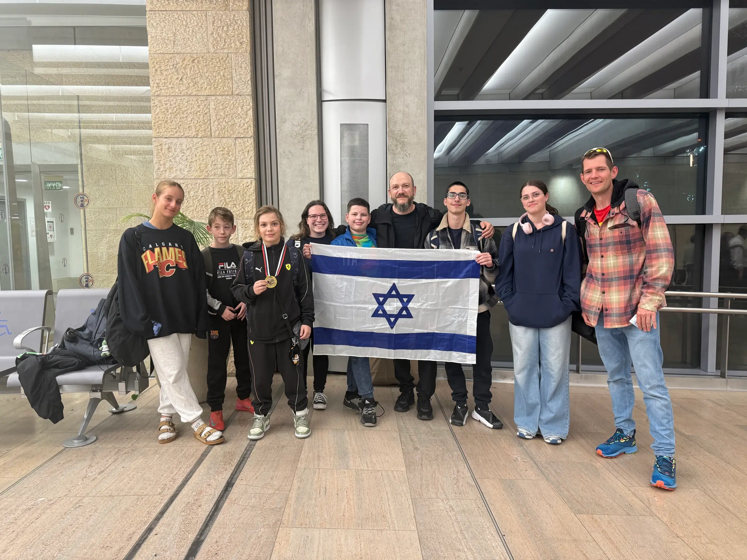 Melissa, family members and friends holding an Israeli flag at the airport