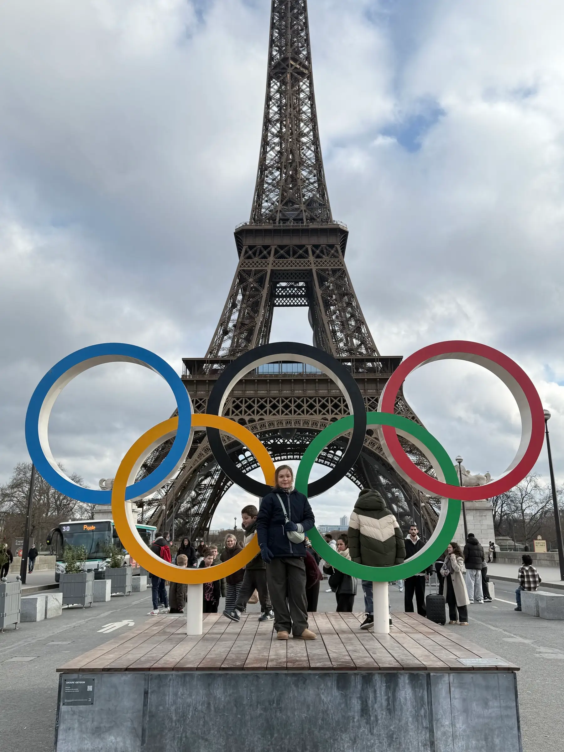 A photo in front of the Eiffel Tower and the Olympic rings