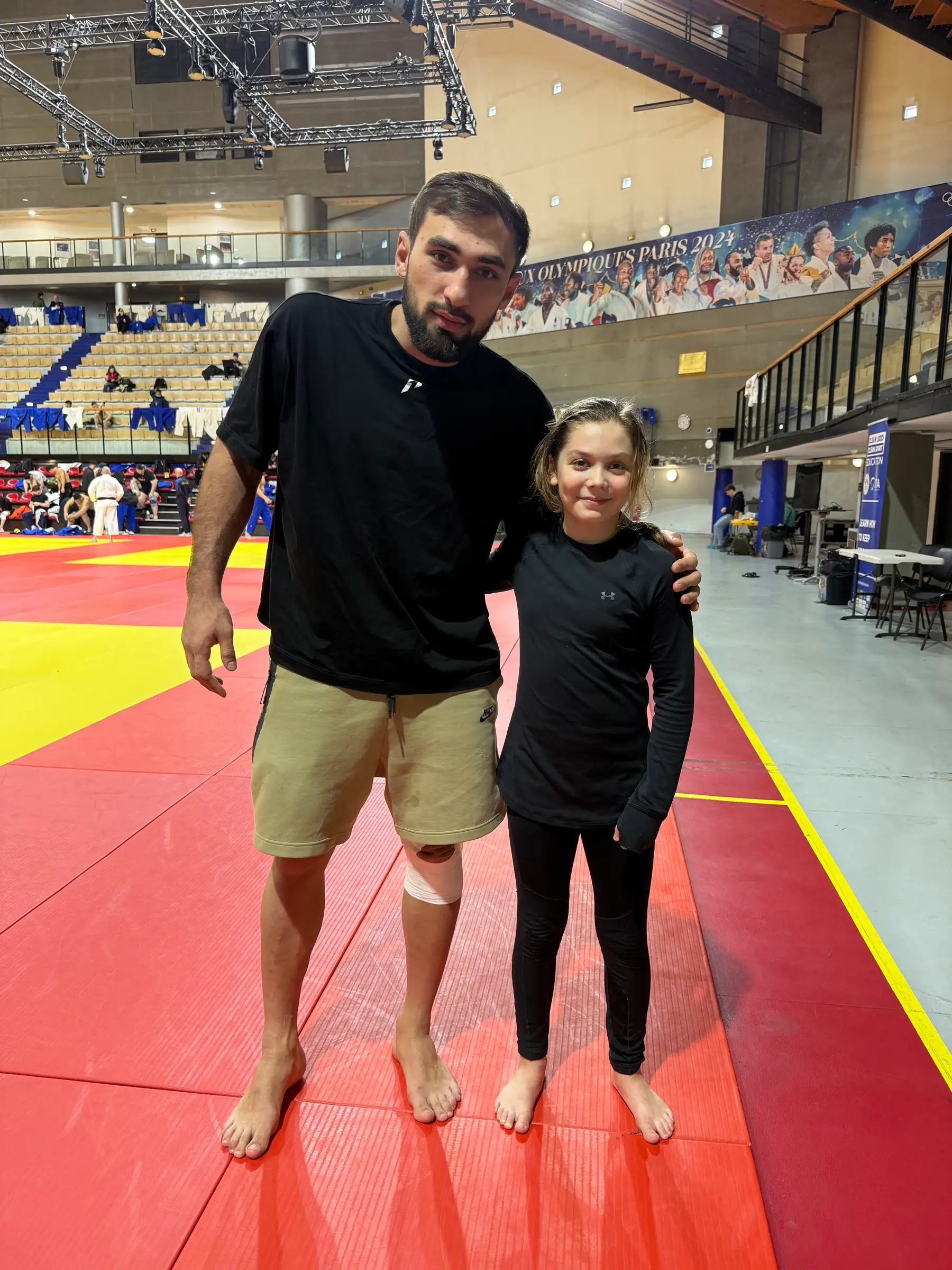 Melissa and a man in a black shirt on the hall’s mat