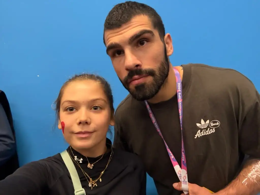 Melissa and a man in a selfie against a blue background
